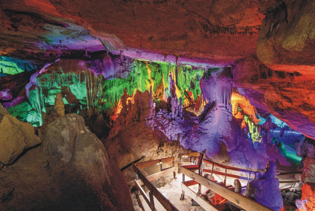 A photo showing Racoon Mountain Caverns with rainbow lights illuminating the cavern walls