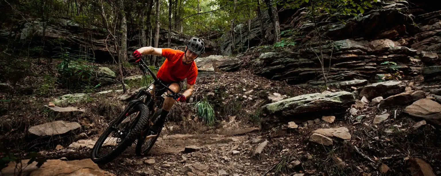 A mountain biker riding down some rugged terrain 