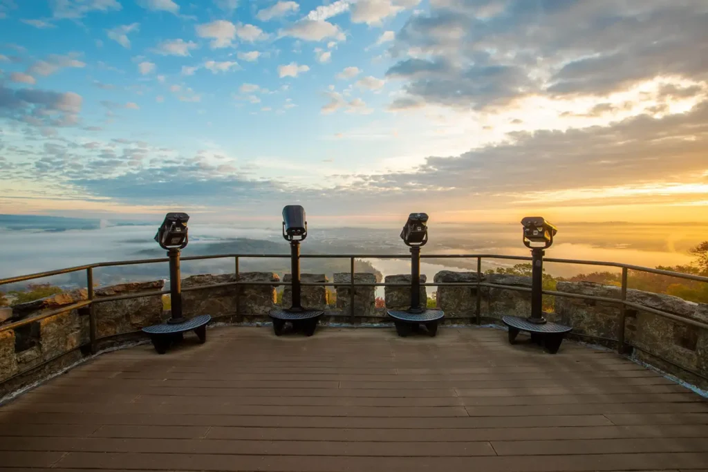 elevated observation deck featuring four coin-operated binoculars, positioned at intervals along a metal railing