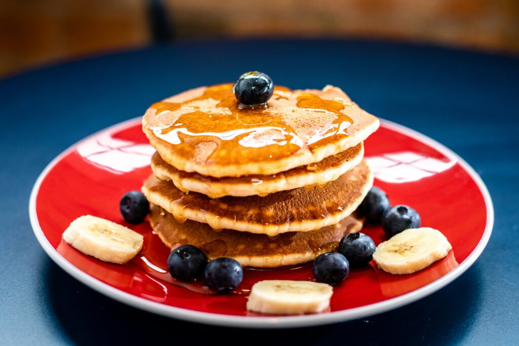 Stack of pancakes with banana slices and blueberries