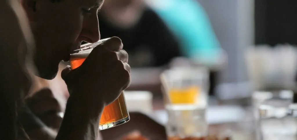 Person sipping on a glass of beer