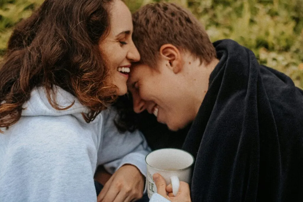 A couple smiling and cuddling on a romantic glamping getaway in Tennessee