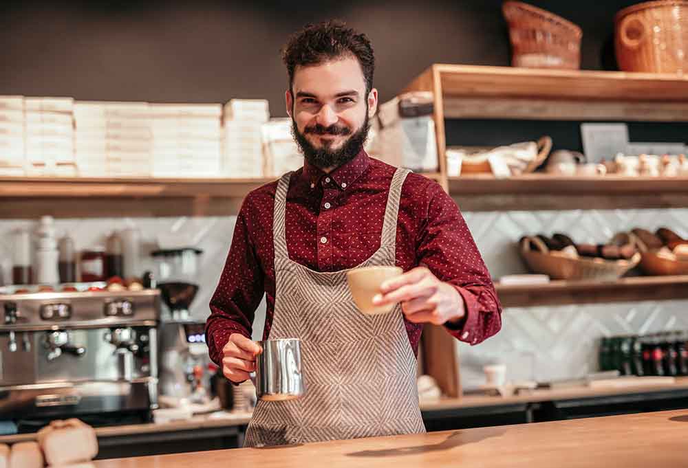 Male barista serving a cup of coffee