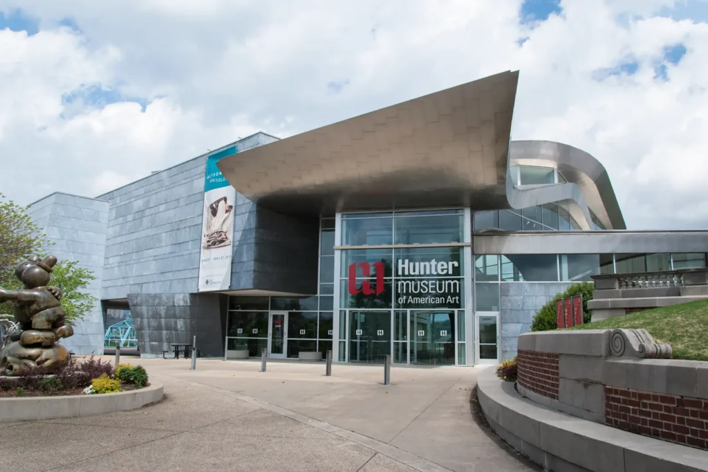 Exterior view of the Hunter Museum of American Art in Chattanooga, Tennessee. The modern building features angular metal architecture, glass windows, and a bold overhanging roof.