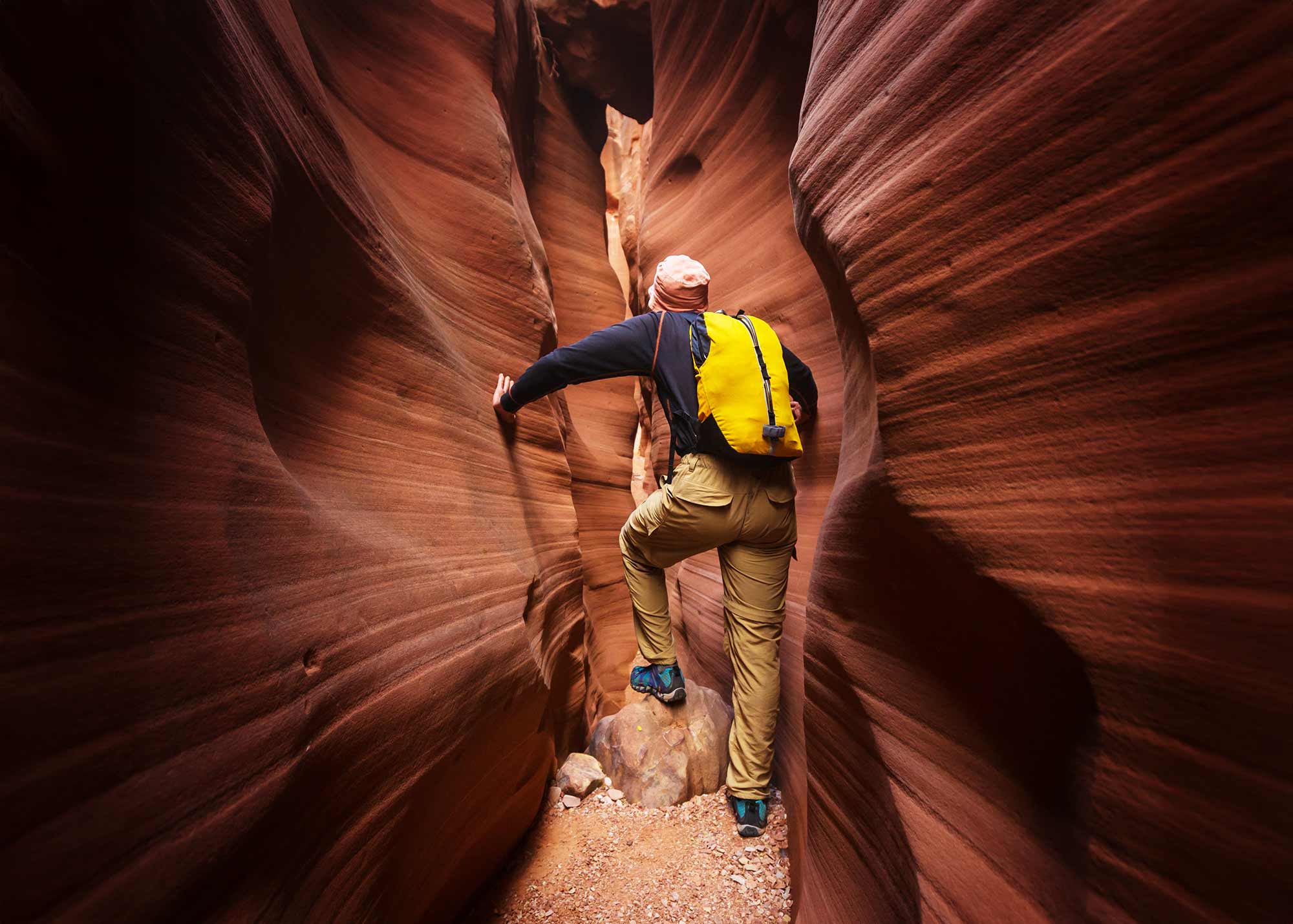 Man hiking through Spooky Gulch Slot Canyon in Utah