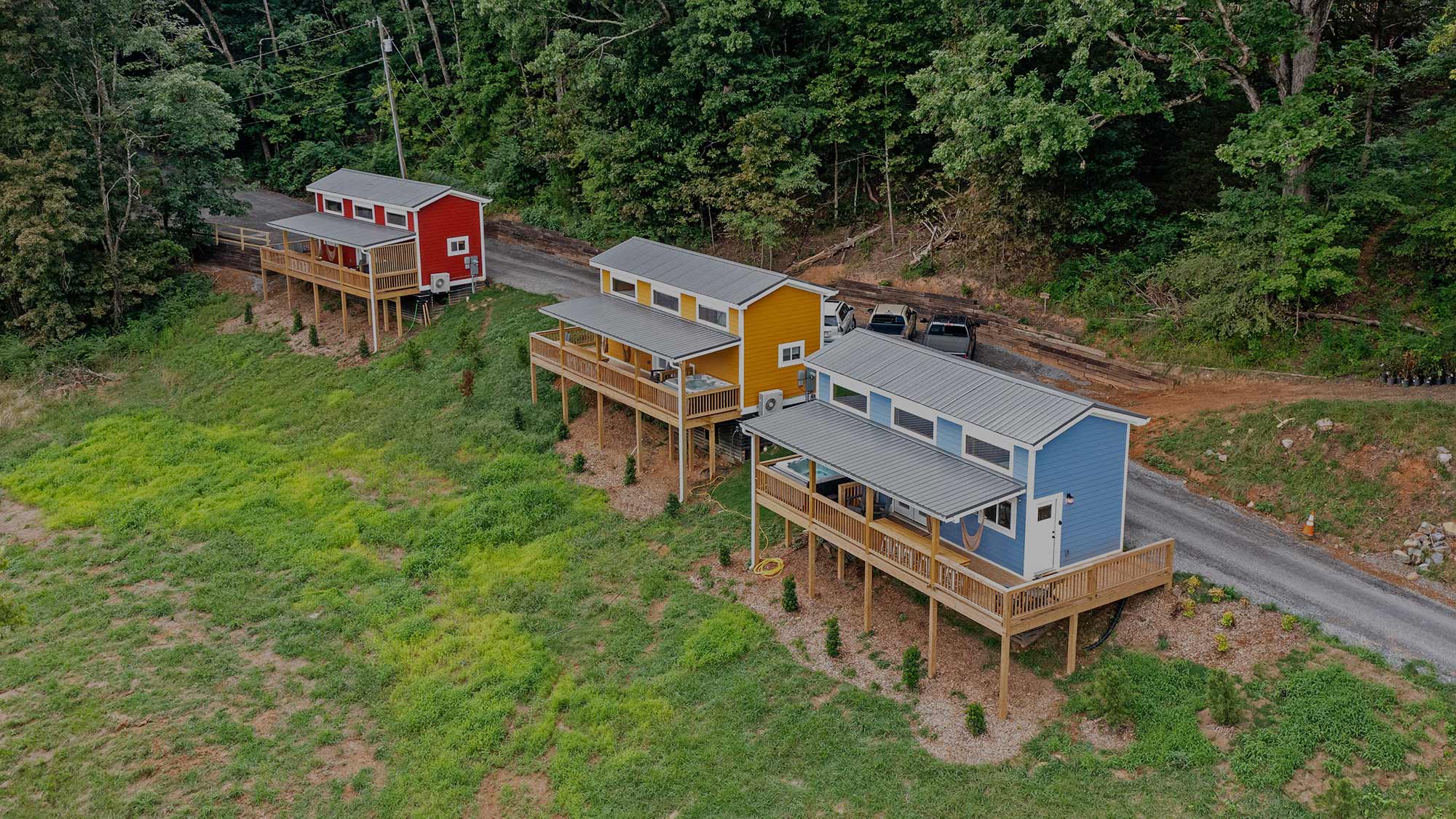 Colorful tiny cabins at Quail Run Farms in Chattanooga, Tennessee, with red, yellow, and blue exteriors overlooking the hillside.