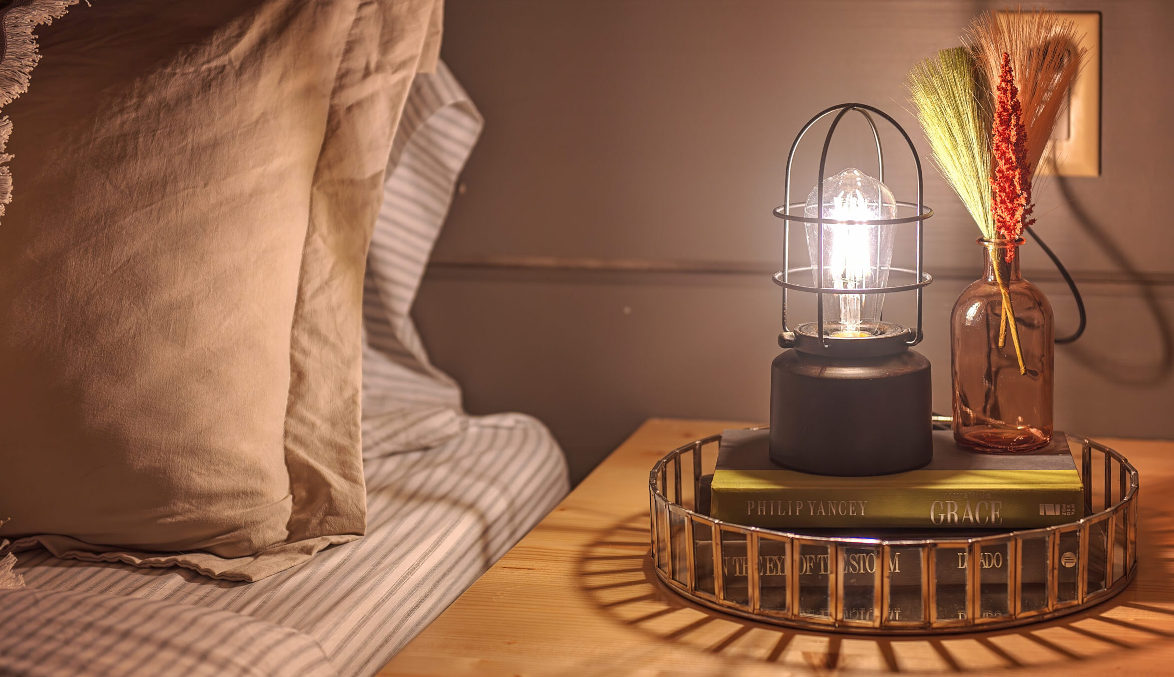 a warm lamp sits atop a pile of books at a cabin at Wauhatchie Woodlands