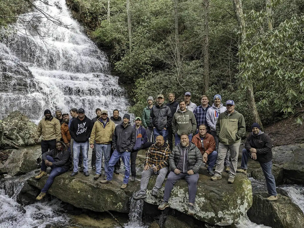 Group of hikers standing on rocks in front of Benton Falls in Polk County, Tennessee