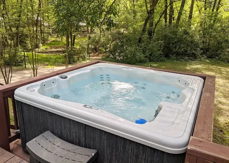 hot tub on the porch of a tiny cabin in the woods