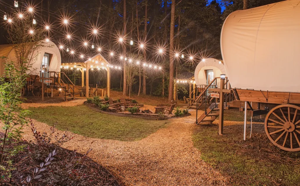 Glamping wagons lit with string lights at Welcome Valley Village campground