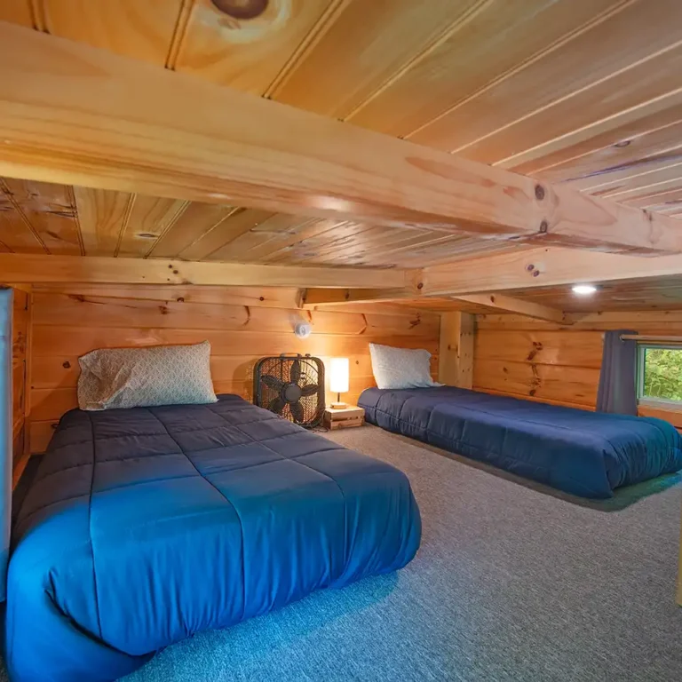 sleeping beds in a loft of a tiny cabin