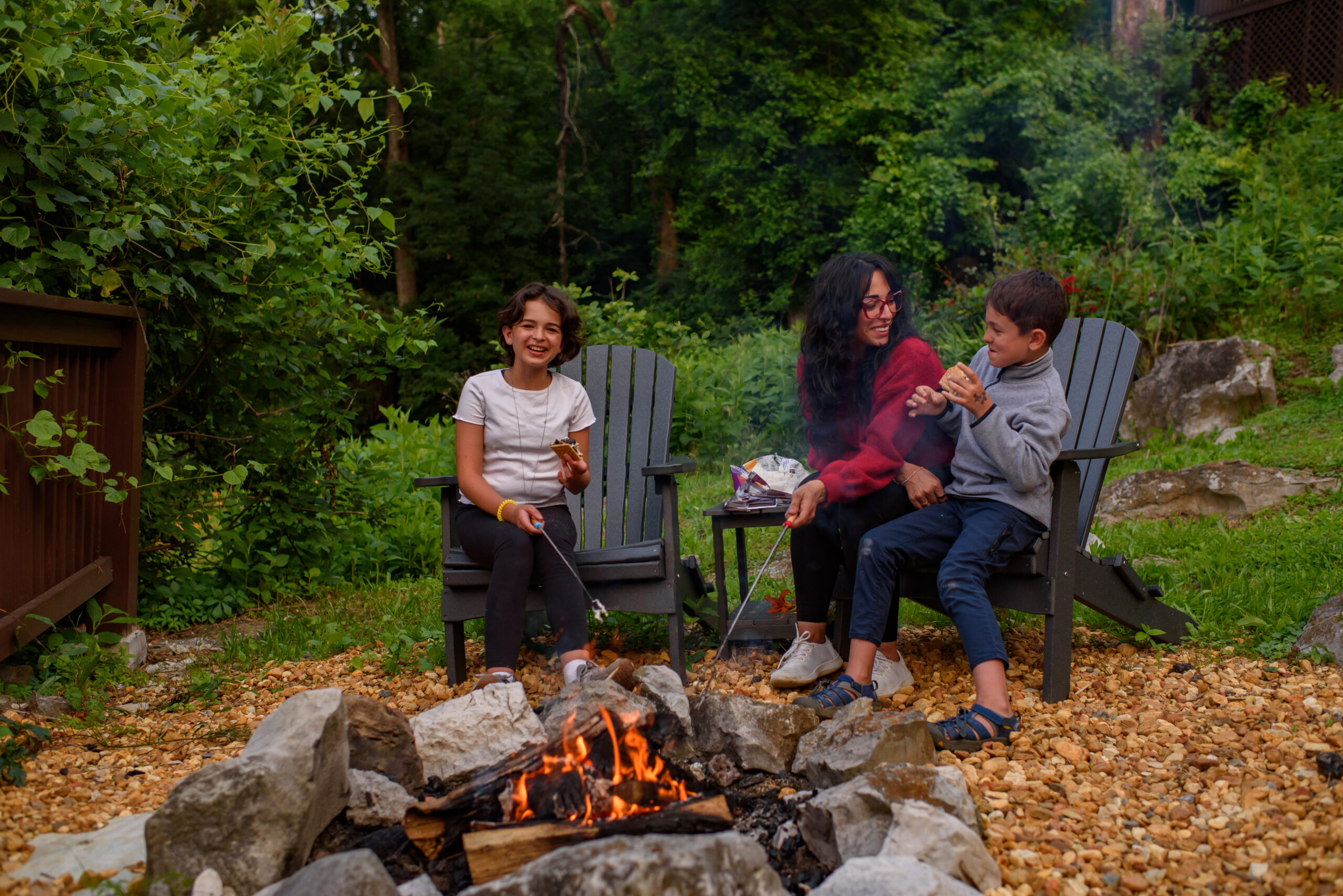 a family around a firepit eating smores together