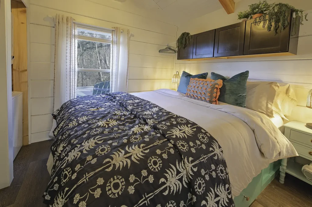 Queen bedroom inside a tiny cabin at Wauhatchie Woodlands with cozy wood interiors and forest views