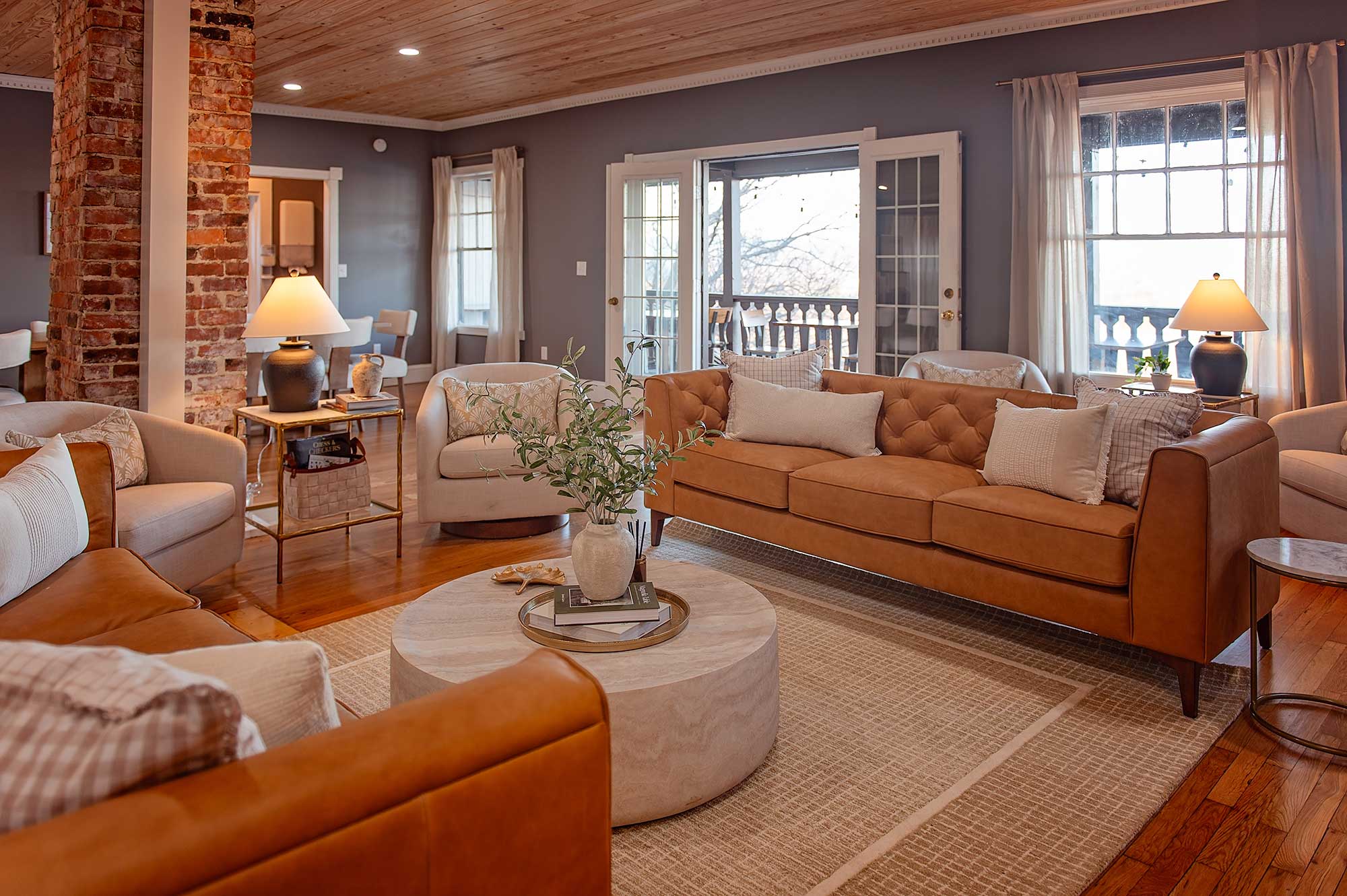 Skybox meeting space at Lookout Mountain Inn with leather sofas, a brick column, and French doors opening to a balcony